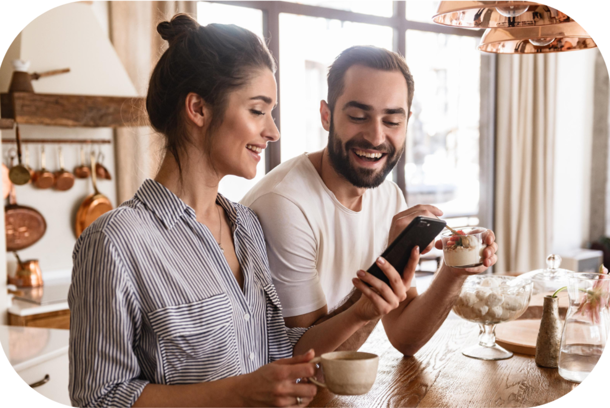 image of couple smiling at phone whilst enjoying Biotiful Kefir and morning drink