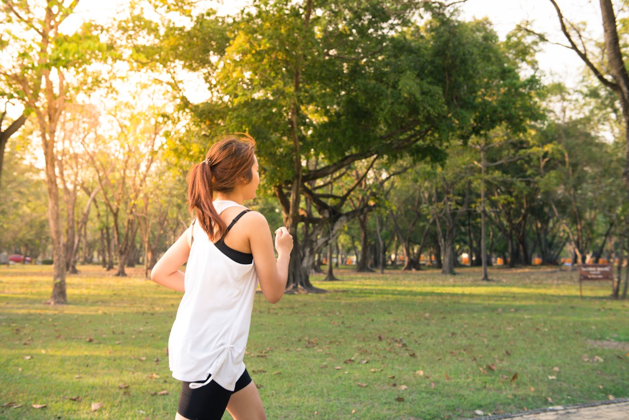 image of woman running through park for blog about natural solutions to runners stomach